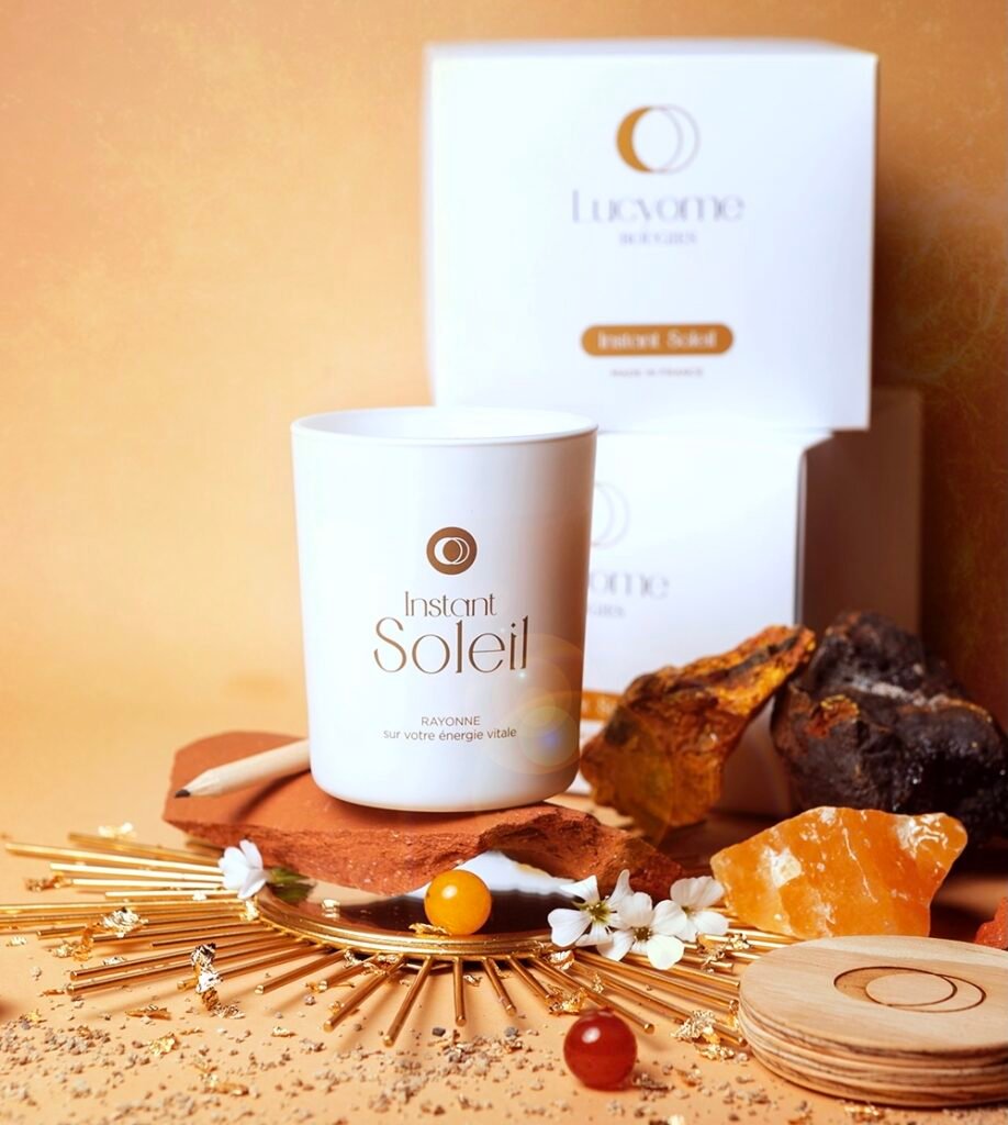 Bougie Instant Soleil Lucyome entourée de pierres ambrées et d’éléments naturels à Toulouse