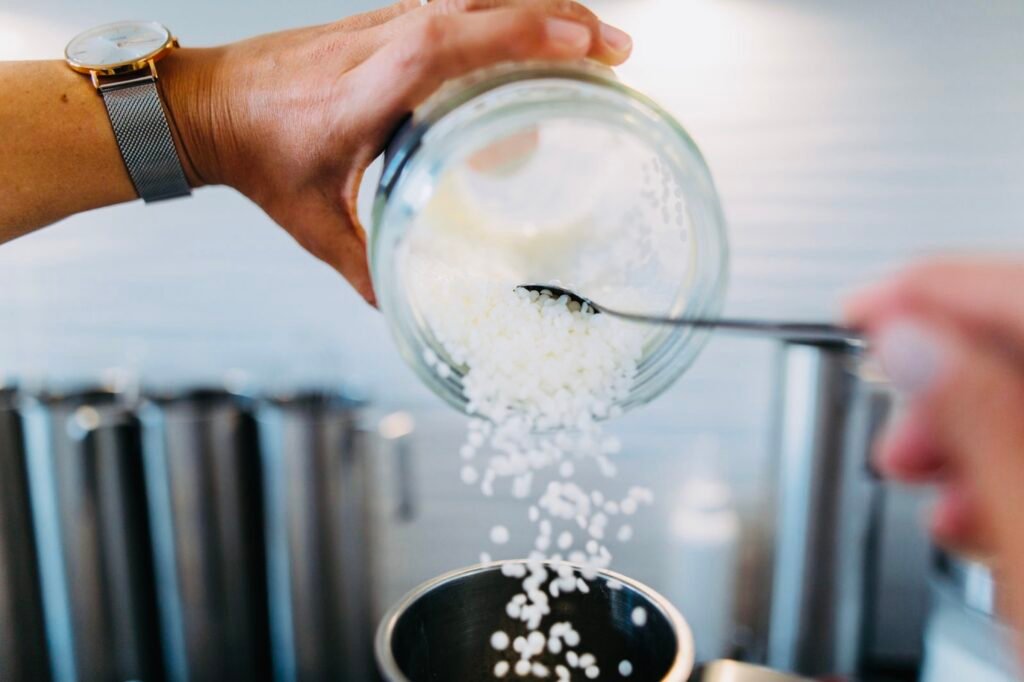Coulée manuelle de cire naturelle dans les ateliers Lucyome à Toulouse pour les bougies parfumées artisanales